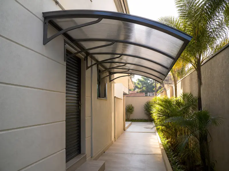 Toldo de policarbonato sobre corredor residencial em Ribeirão Preto